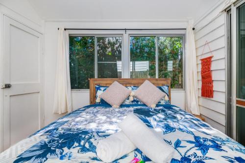 a blue and white bed in a room with a window at The Forest Lodge in Mount Tamborine