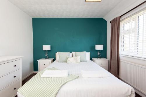 a bedroom with two beds and a blue wall at Broome Road in Durham