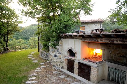 an outdoor oven with a fire in the side of a house at Villa Costa piccola with private pool in Umbria in Umbertide