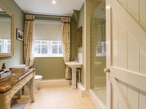 a bathroom with a shower toilet and a sink at The Gate House in Colchester