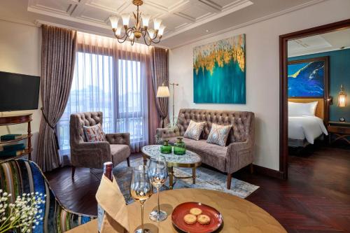 a living room with a couch and a table at Peridot Grand Luxury Boutique Hotel in Hanoi