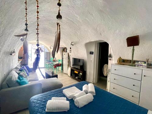 een slaapkamer met een blauw bed en handdoeken bij Mermaid Cave Apartment Old Port, Fira in Fira