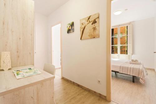 Cette chambre blanche comprend un lit et une table. dans l'établissement AB Vila i Vila Apartments, à Barcelone