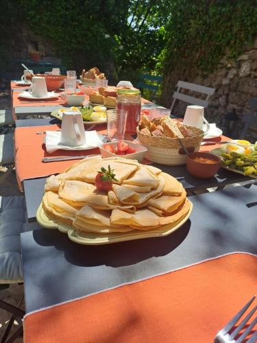 une longue table avec des assiettes de nourriture dans l'établissement Les Roses Trémières, à Bargème