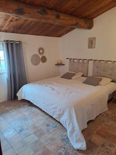 une chambre avec un grand lit dans une pièce dans l'établissement Les Roses Trémières, à Bargème