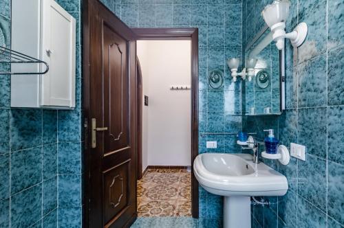 a blue bathroom with a sink and a toilet at Cagliari Comfy Apartment with Terrace & Netflix! in Selargius