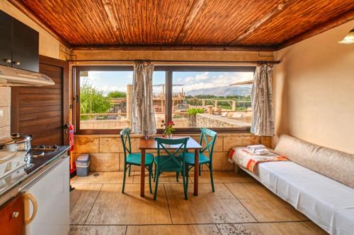 a kitchen with a table and chairs in a room with a window at Anemomili Village in Kissamos