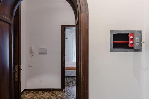 a hallway with a mirror and a door with a television at Cagliari Comfy Apartment with Terrace & Netflix! in Selargius