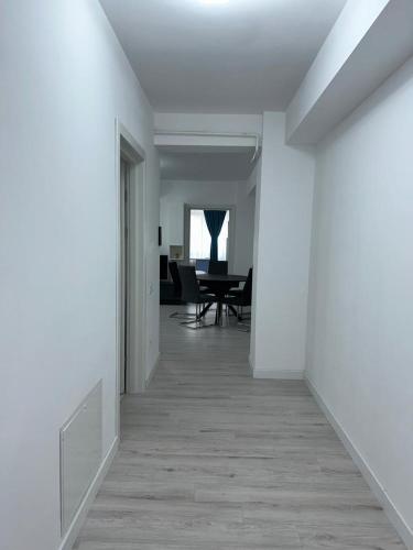 an empty hallway with white walls and a table at Marvellous Aparthotel with Master Apartments Suceava in Suceava
