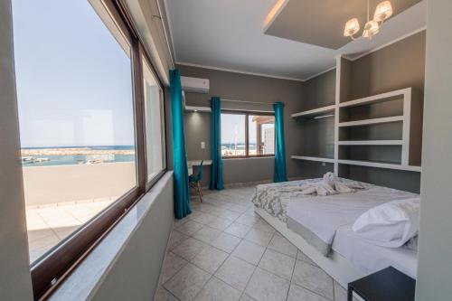 a bedroom with a bed and a view of the beach at Luxury Sea View Apartment in Kolimvari in Kolymvari