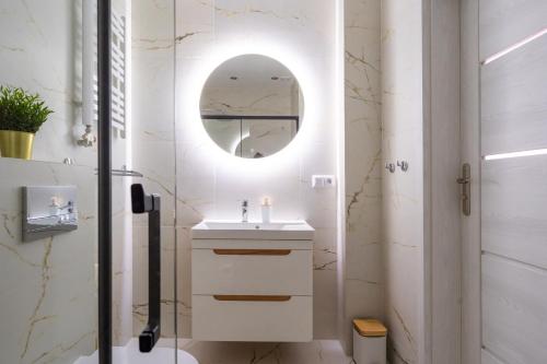 een badkamer met een wastafel en een spiegel bij Apartamenty Olchowa z tarasem w spokojnej okolicy - Dream Apart in Ustroń