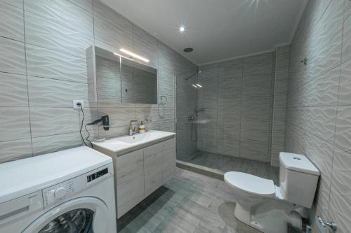 a bathroom with a washing machine and a toilet at Luxury Sea View Apartment in Kolimvari in Kolymvari