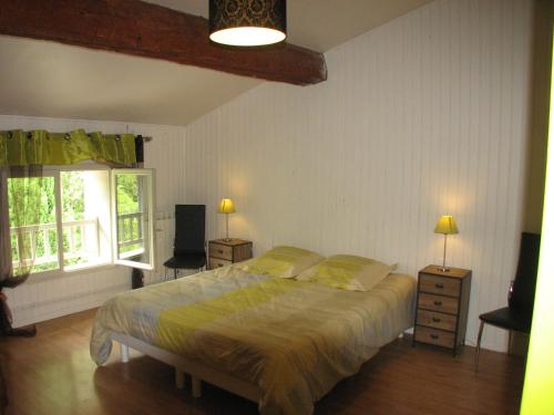 - une chambre avec un grand lit et 2 fenêtres dans l'établissement Domaine Saint-Joly, à Lasbordes