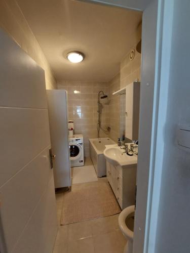 a bathroom with a sink and a toilet and a microwave at Apartman LAURA in Zagreb