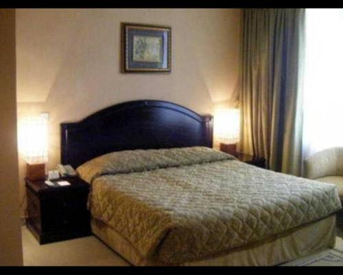 ドバイにあるcomfort zone for accommodationのベッドルーム1室(ベッド1台、テーブルの上にランプ2つ付)