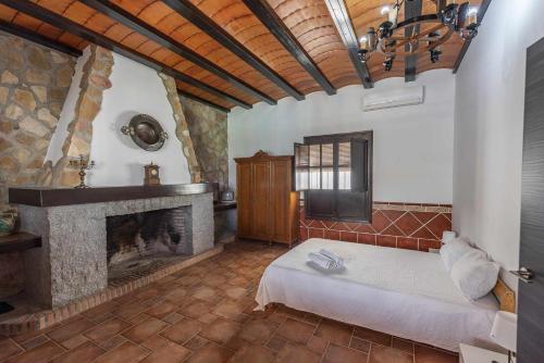 una camera con camino e un letto in una stanza di Casa Rural Villa Cerro Mena a La Lantejuela