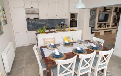 uma cozinha e sala de jantar com mesa e cadeiras em Villa GreenTree - Fully Refurbished in 2023 em Budakalász