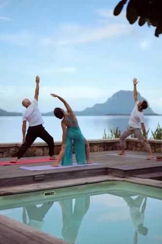 a group of people doing yoga by a pool at La Cabane du Pecheur in Rivière Noire