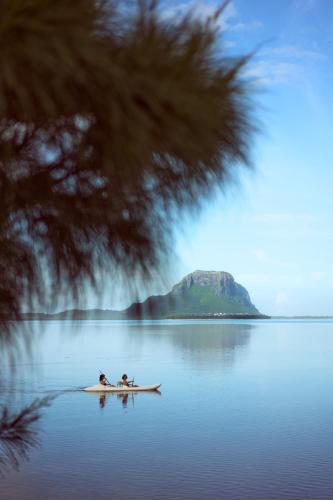 a couple of people sitting on a kayak in the water at La Cabane du Pecheur in Rivière Noire