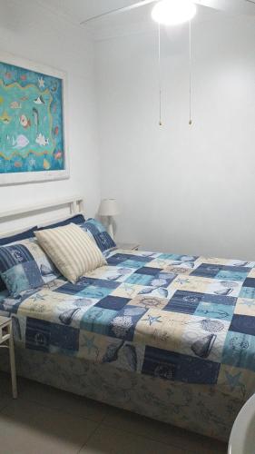 a bedroom with a bed and a painting on the wall at Afsaal Sea view apartments in Amanzimtoti