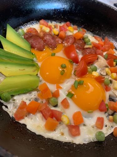 a frying pan filled with eggs and vegetables at The Gallery Hotel Nai Harn in Nai Harn Beach