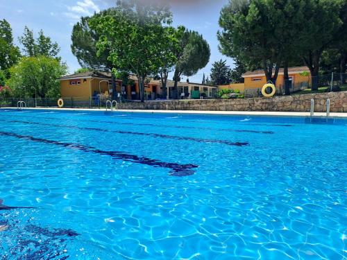 uma grande piscina de água azul com árvores ao fundo em Casa El Frenazo 