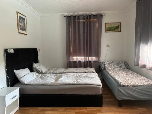 two beds in a room with a window at Oslo House, Nedre Kjellerstuvei, First floor, Twin Room in Lillestrøm