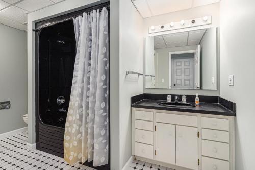 a bathroom with a sink and a shower with a mirror at The Big Blue Lakehouse in Berrien Springs