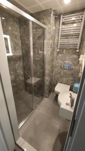 uma casa de banho com um chuveiro, um WC e um lavatório. em Hotel Torun Istanbul Old City em Istambul