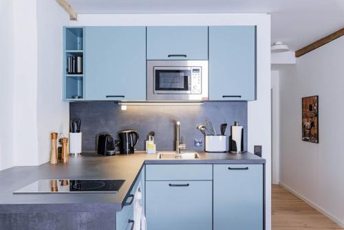 a kitchen with white cabinets and a microwave at Limehome Dachau Konrad-Adenauer-Str in Dachau