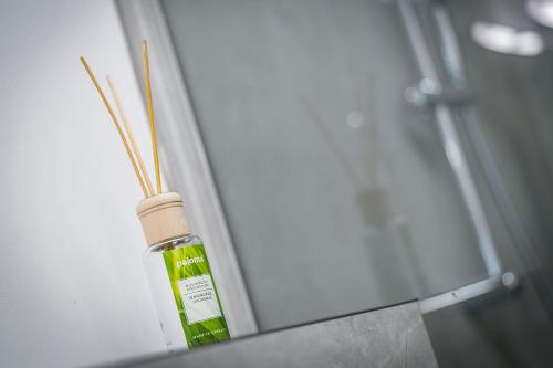 a bottle of green essential oil next to a shower at Nice Apartment in Offenbach a. M. in Offenbach