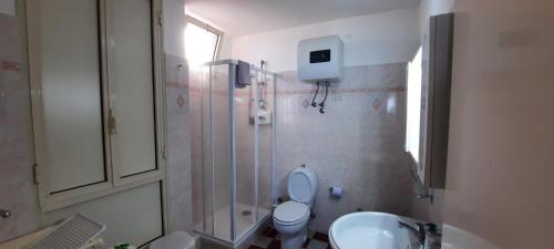a bathroom with a shower and a toilet and a sink at Appartamento Ancora in Roccalumera