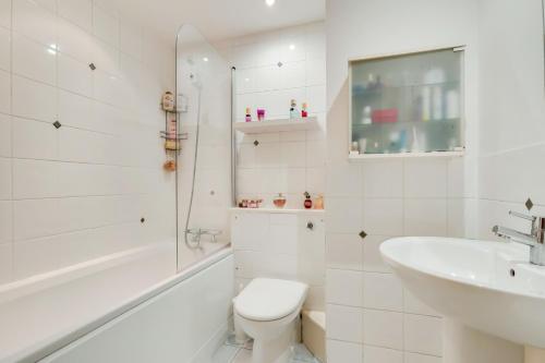 a white bathroom with a toilet and a sink at Spacious 2 bed 2 bath Kings Cross Apartment in London
