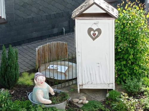a garden with a small out house and a statue at Ferienwohnung Sauerland Burgfenster in Lennestadt