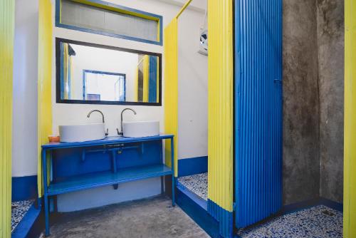 W łazience znajduje się niebieska umywalka i lustro. w obiekcie Echo Hostel Koh Tao w Ko Tao