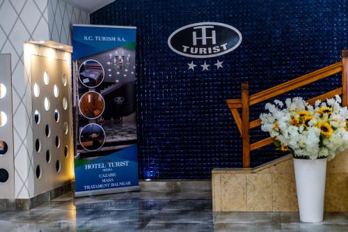 a room with a vase of flowers and a wall at Hotel Turist in Pucioasa