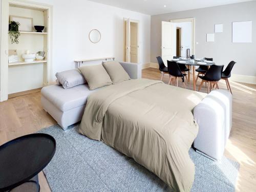 1 dormitorio con 1 cama, mesa y sillas en Appart'Hôtel Le Jaurès - Jardin privé et Netflix, en Belfort