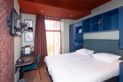 um quarto com uma cama e uma secretária com um computador em Hotel Nicolaas Witsen em Amesterdão