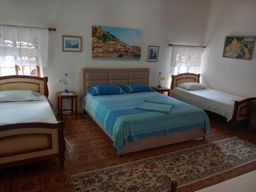 1 dormitorio con 2 camas y 2 ventanas en Guesthouse & hostel Lorenc, en Berat