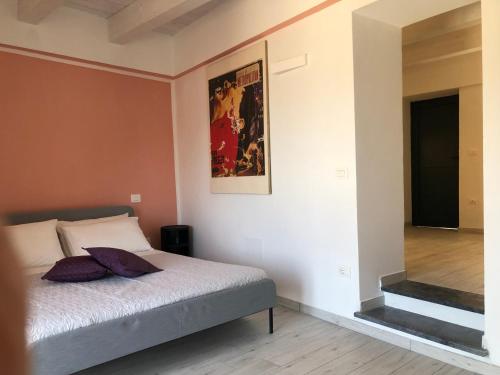 1 dormitorio con 1 cama y una pintura en la pared en Un Capriccio - Mirto, en Aieta