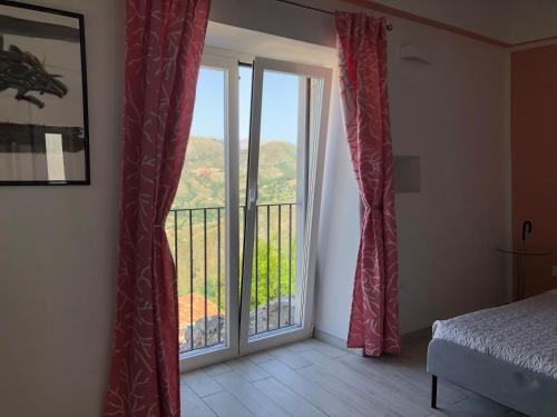 1 dormitorio con puerta que da a un balcón en Un Capriccio - Mirto, en Aieta