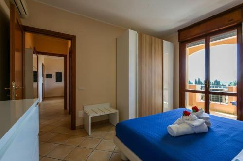 ein Schlafzimmer mit einem blauen Bett und einem Balkon in der Unterkunft Uno sguardo sul mare - Apartment - in Quartu SantʼElena