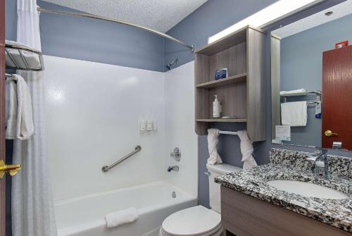 a bathroom with a tub and a sink and a toilet at Microtel Inn & Suites by Wyndham Dry Ridge in Dry Ridge