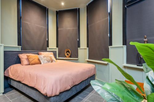 een slaapkamer met een bed met roze lakens en kussens bij 't Hoekje in Enschede