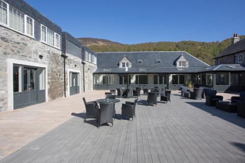 a patio with tables and chairs in a building at Dunalastair Hotel Suites in Kinloch Rannoch