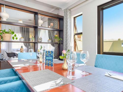 una sala da pranzo con tavolo e bicchieri da vino di Mercure Hotel Bedfordview a Johannesburg