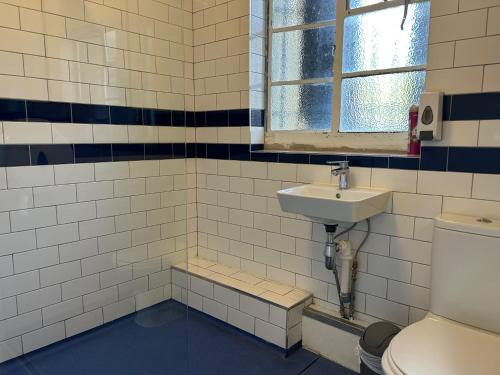 a bathroom with a sink and a toilet at Cricketers Hostel in London