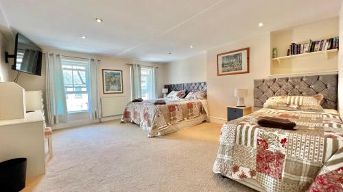 a bedroom with two beds and a television in it at 3 Bedroom Character Townhouse on Edge of Blackdown Hills in Wellington
