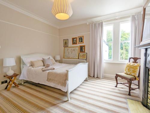 a bedroom with a white bed and a chair at La Maison De La Mer, Worthing in Worthing