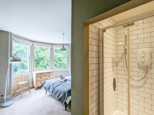 a bathroom with a shower and a bed in a room at La Maison De La Mer, Worthing in Worthing